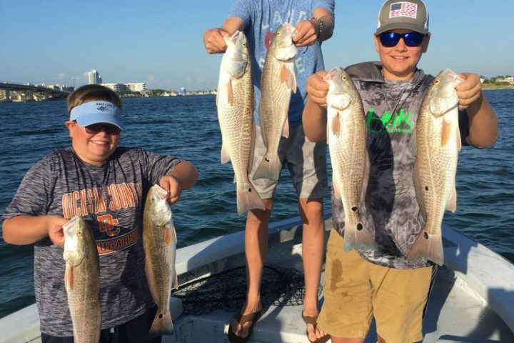 a group of people standing in front of a fish