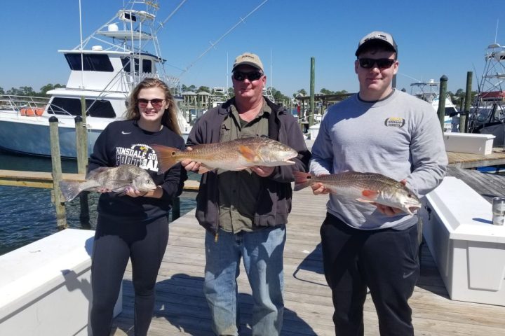 a person holding a fish on a boat posing for the camera