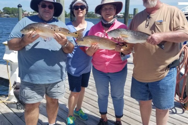 a group of people standing next to a person holding a fish