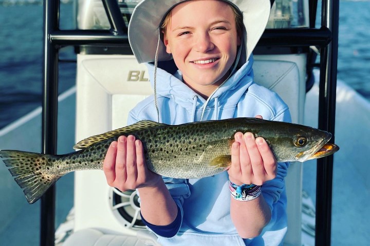a person holding a fish on a boat in the water