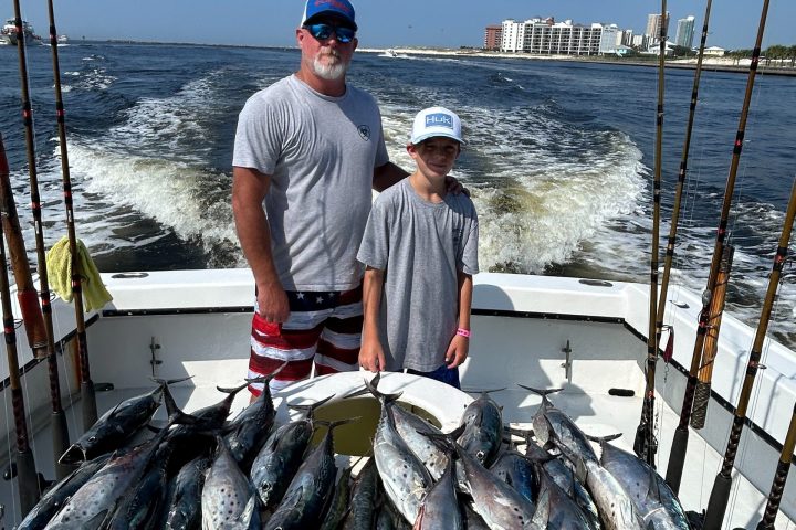 a man holding a fish on a boat in the water