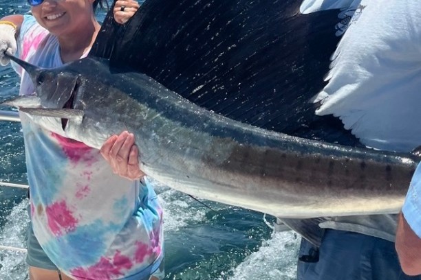 a man holding a fish in the water