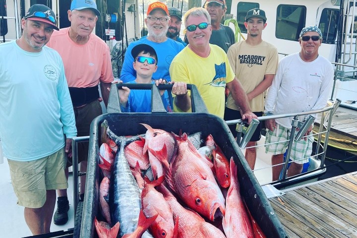 Jack Nicklaus et al. standing next to a person holding a fish