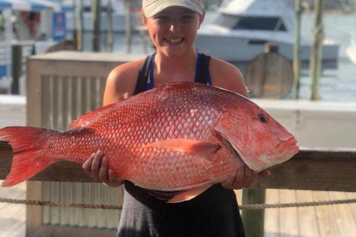 a woman holding a fish