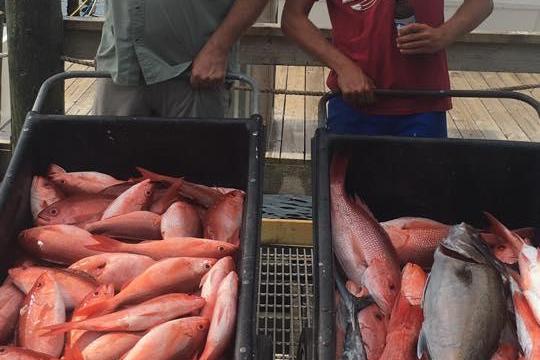 a man cooking hot dogs on a grill
