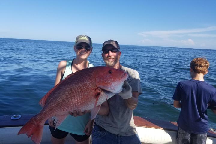 a person holding a fish in the water