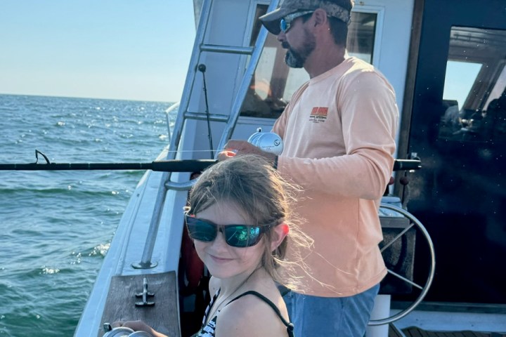 a man standing next to a body of water