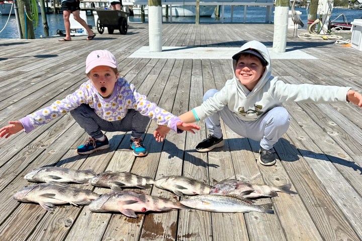 a group of people sitting around a wooden fence