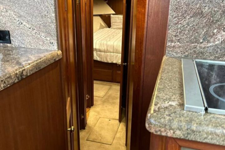 a kitchen with a stove top oven sitting inside of a wooden door
