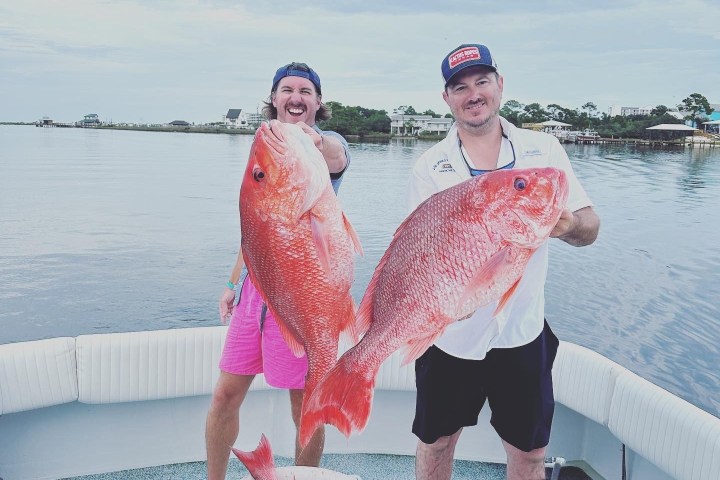a man and a woman standing next to a body of water