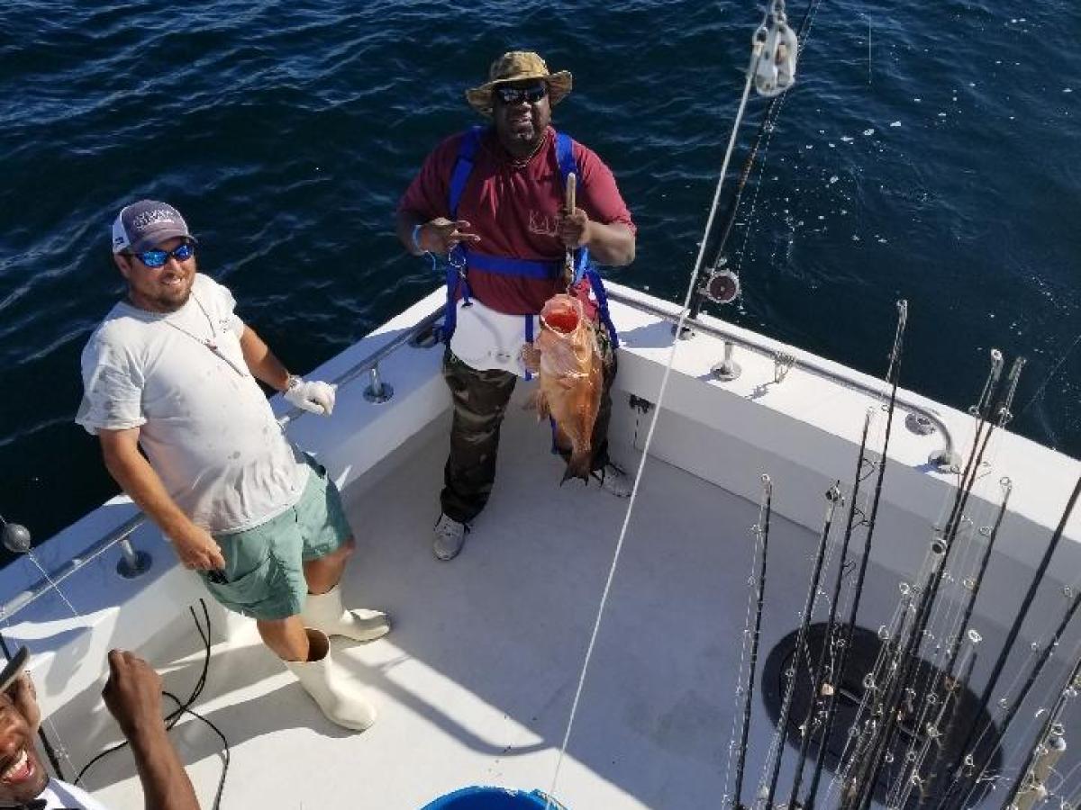 a man riding on the back of a boat in the water