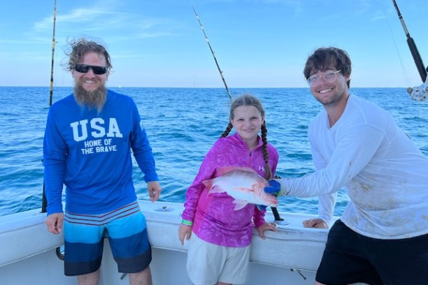 a man and a woman standing next to a body of water