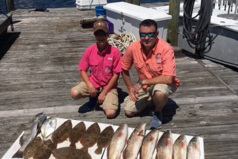 a person holding a fish on a wooden bench