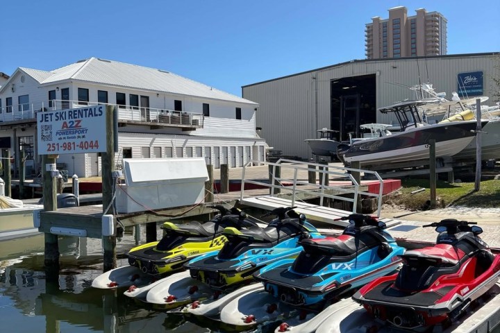 a small boat in a body of water with a city in the background