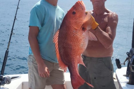 a person holding a fish on a boat