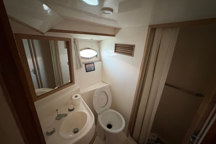 Small bathroom with sink, mirror, and toilet on a boat.